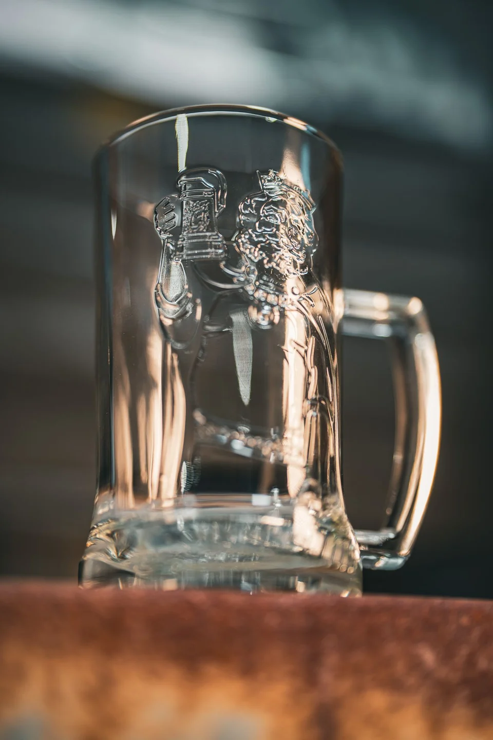 Clear handled Gambrinus beer glass with the embossed king design, photographed on a wooden crate