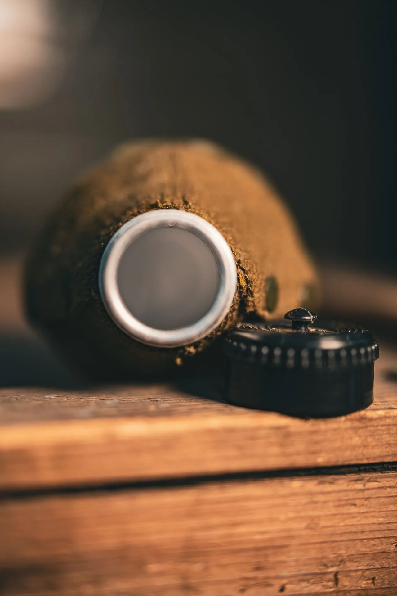 Bare aluminum mouth of the Romanian canteen with the black bakelite screw cap detached and resting alongside