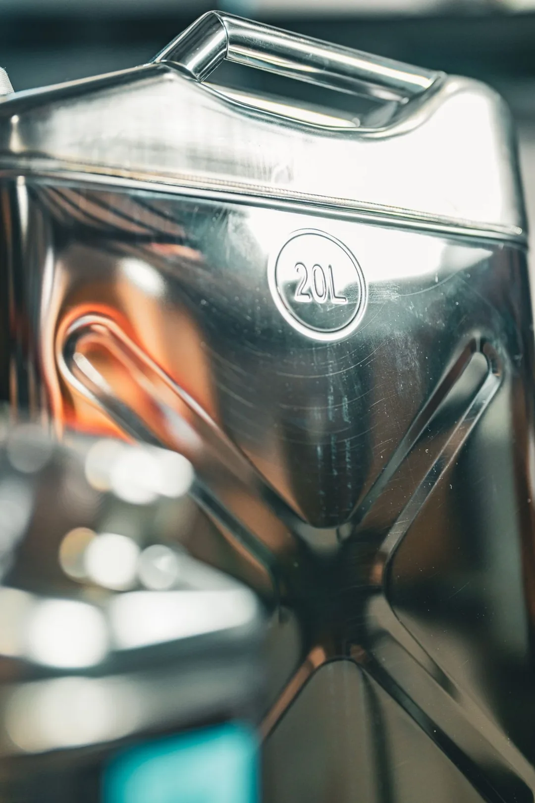 Close-up of the 20 liter Swiss Link stainless steel water can showing the embossed 20L badge and the welded body seams