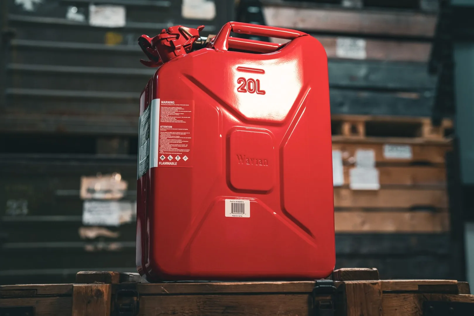 Wavian 20L Red Jerry Can on a wooden crate against a warehouse pallet rack