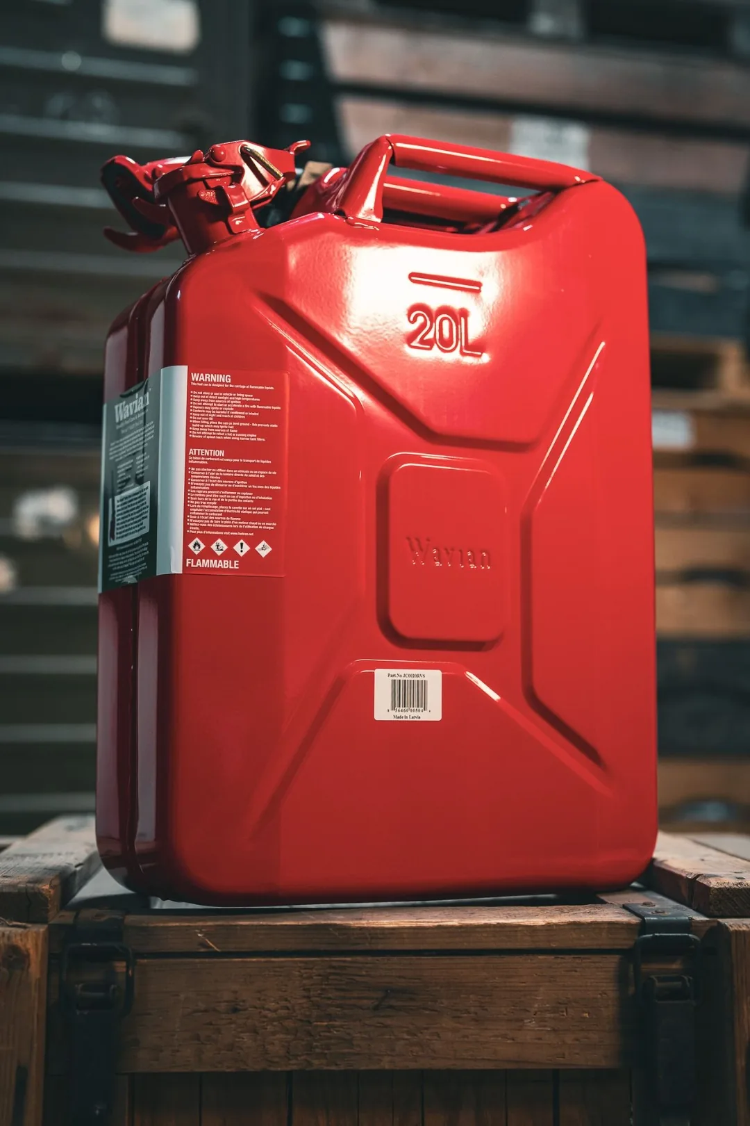 Wavian 20L Red Jerry Can on a wooden crate, showing the embossed Wavian panel and Made in Latvia barcode label