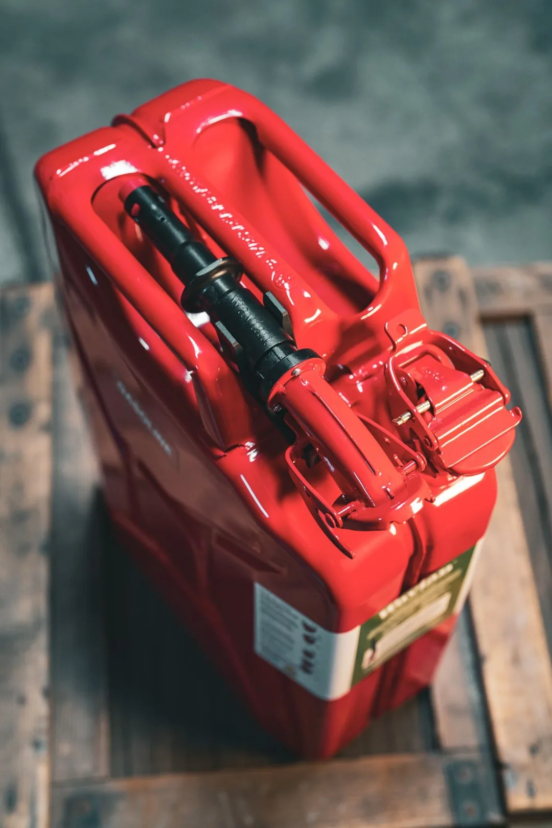 Top-down view of a Wavian jerry can with the safety spout clipped into its carry bracket next to the handle