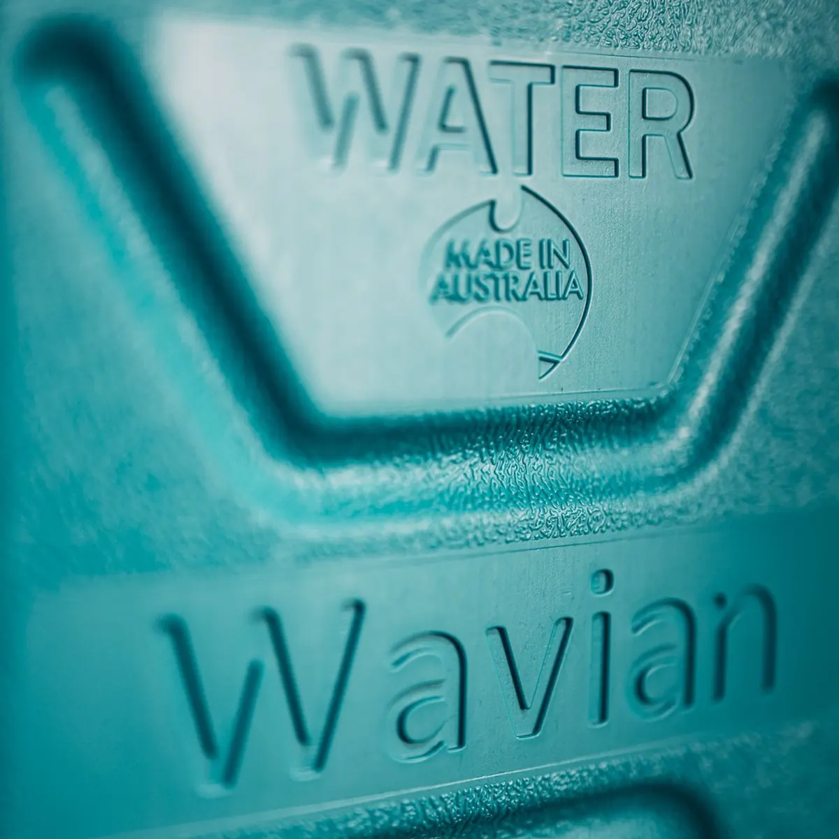 Close-up of the textured front panel of the Wavian water can, with WATER, the Made in Australia mark and the Wavian name molded into the plastic