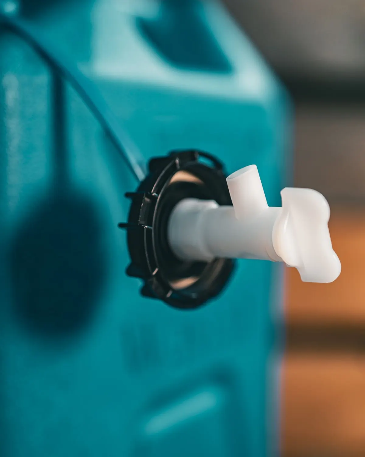 White detachable tap threaded into the lower port of the Wavian water can